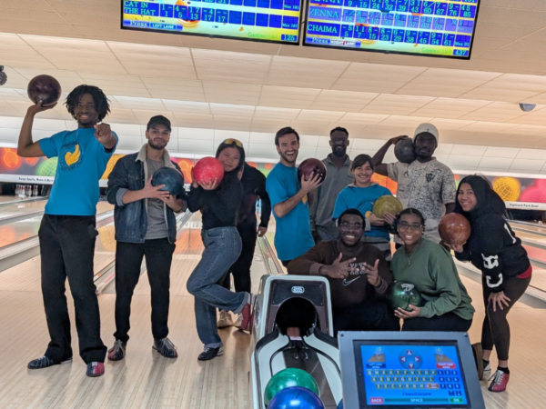 International students at the bowling alley posing with bowling balls.