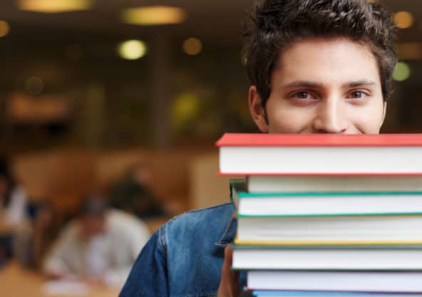 male student with stack of books