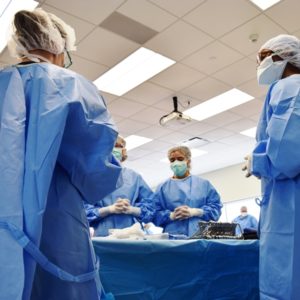 Surgical Technology students in blue scrubs working in lab
