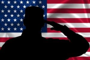 silhouette of soldier saluting with U.S. flag in background