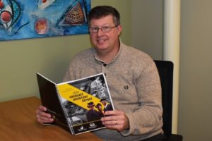 BHC staff member Dale Huntley reading college catalog