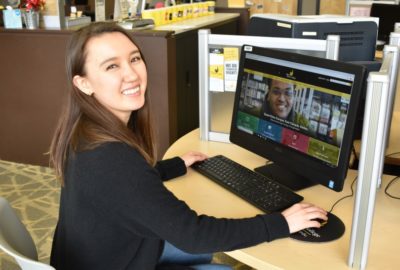 female student at computer with Black Hawk College website open