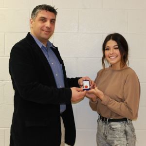 instructor and student holding award pin