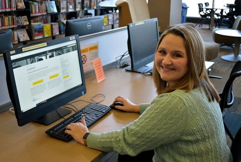 sitting female student using a computer in a library