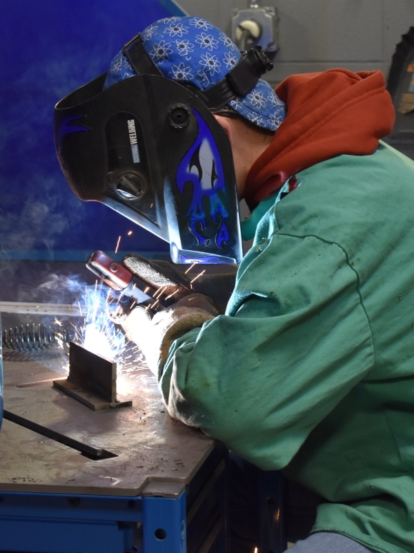 student welding and wearing protective equipment