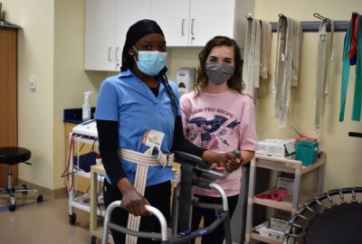 two physical therapist assistant students with a walker in a classroom