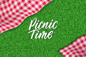 Words picnic time on grass next to checkered tablecloth