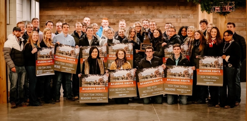 38 people smiling with award banners