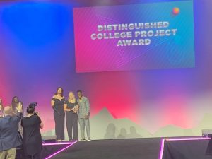 3 people on stage with Distinguished College Project Award