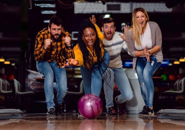 4 excited people bowling