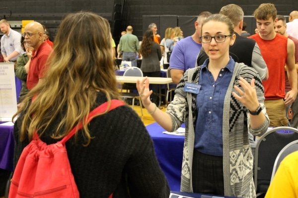 college recruiter standing at table talking to guest