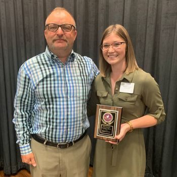 Larson and lizzy holding a plaque