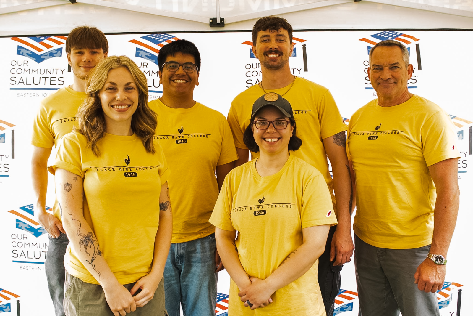 Veterans A group of people in volunteer t-shirts posing for a photo at a veterans' event.