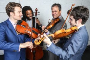 4 male musicians playing string instruments