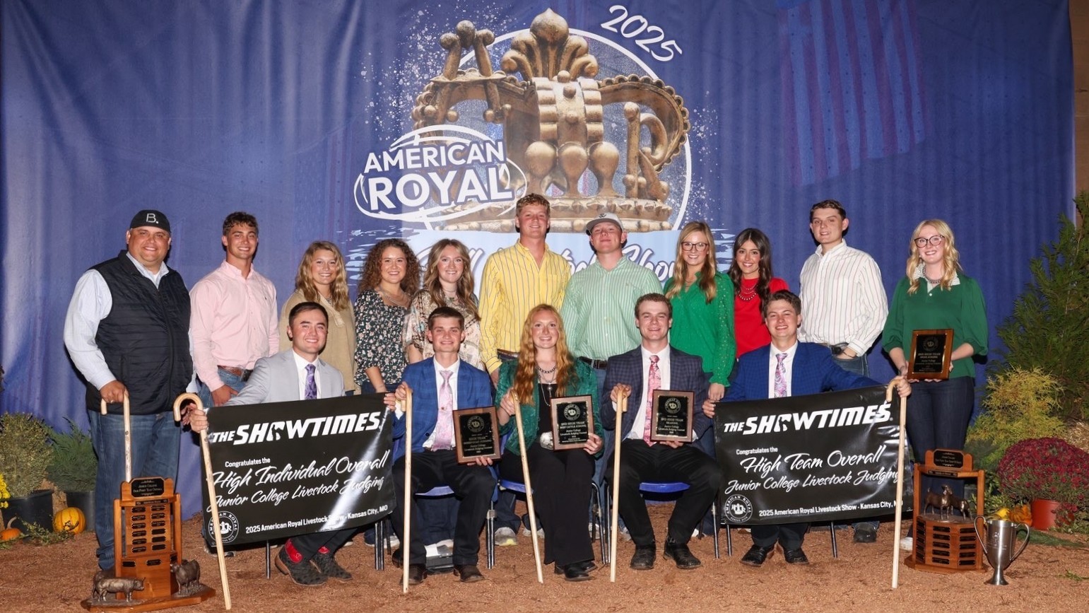 Livestock judging team wins first 3 contests of season 14 livestock judging team members and 2 coaches in front of large backdrop with awards.