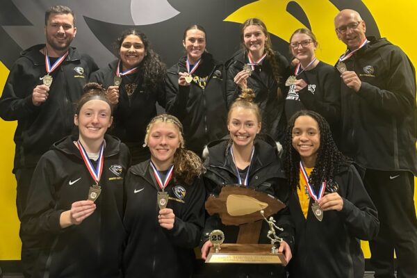 8 women's basketball players and 2 coaches with arrowhead conference championship trophy and medals