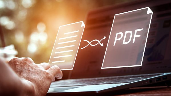 Convert pdf files with online programs. Users convert document files on a platform using an internet connection at desks. Concept of technology transforms documents into portable document formats.