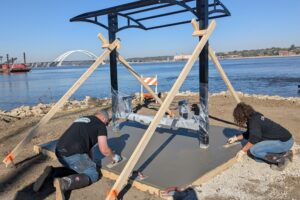 Congrats to fall 2024 highway construction grads 2 people smoothing out concrete pad at picnic table shelter