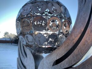 A sculpture of a sphere with persony different symbols