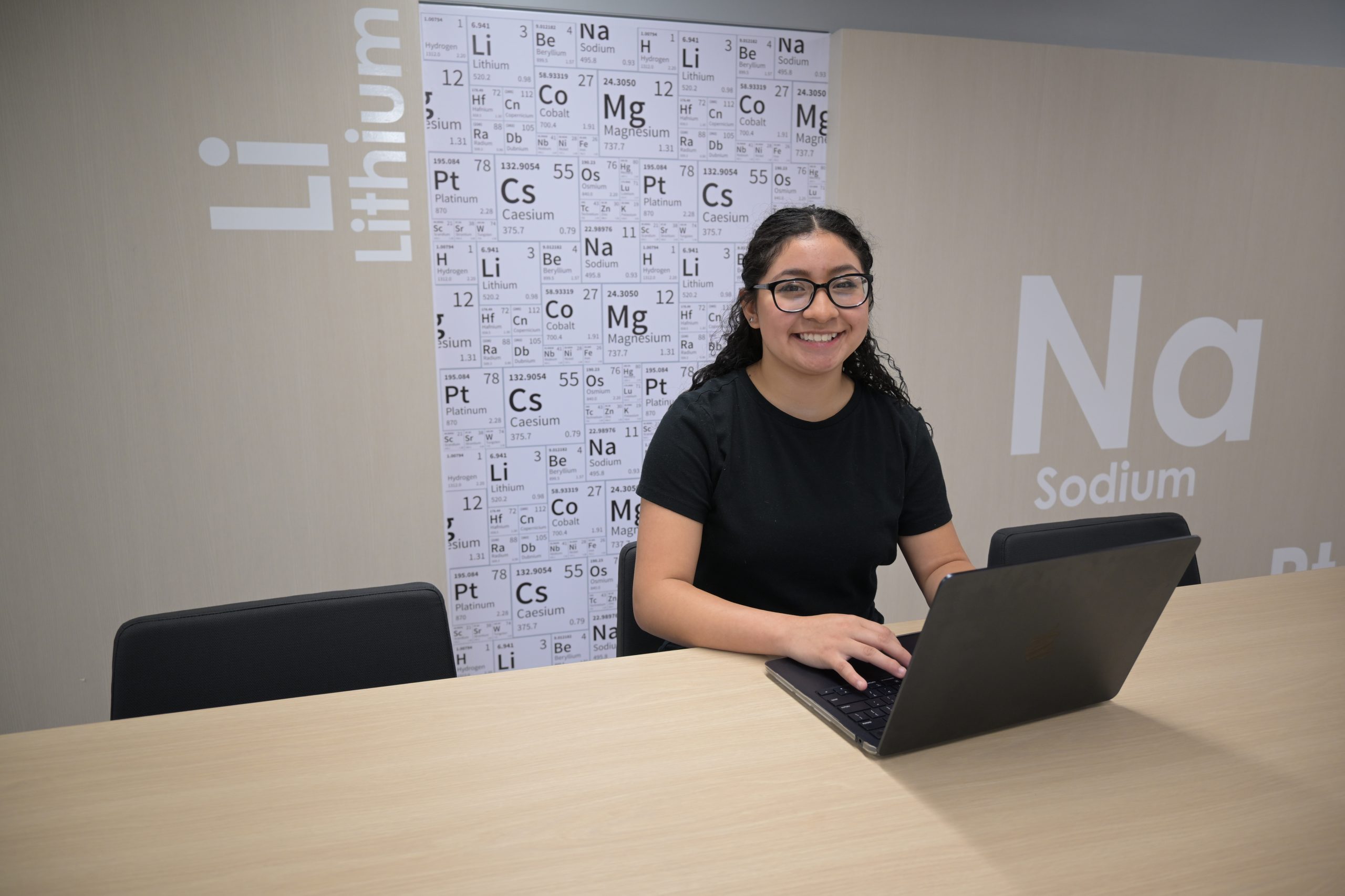 Female student sitting at a desk with a laptop.