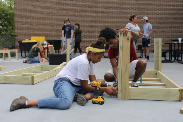 A group of people working on a wood structure