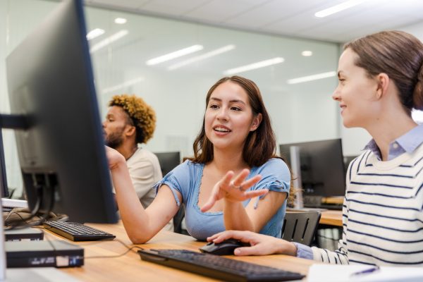 College students working together on a computer. Teamwork, education, technology.