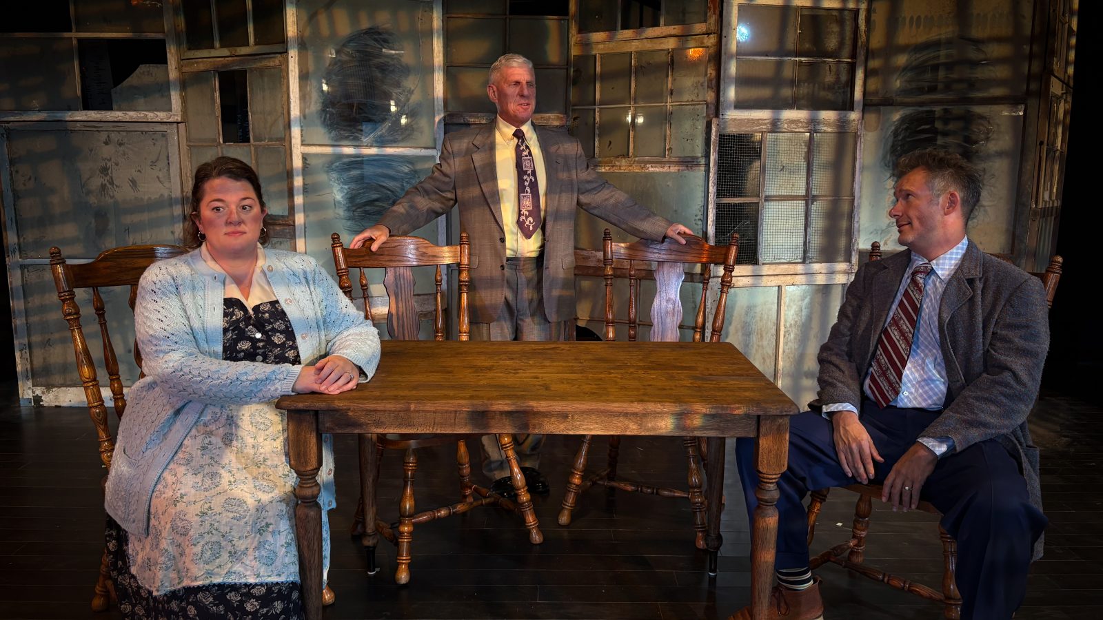 Bhc, mockingbird stage 'death of a salesman' Actors in suits and actress in dress sitting and standing at a wooden table while rehearsing