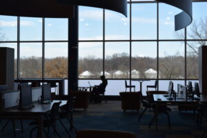 A person sitting in a chair in a room with large windows