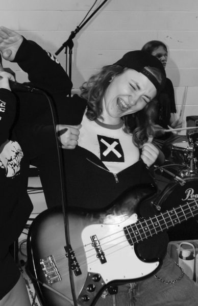 Photo of daisy blunt playing the bass with her band
