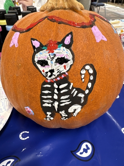 Day of the dead style cat painted on a pumpkin.