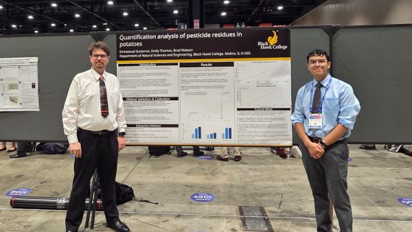 Two men presenting research poster