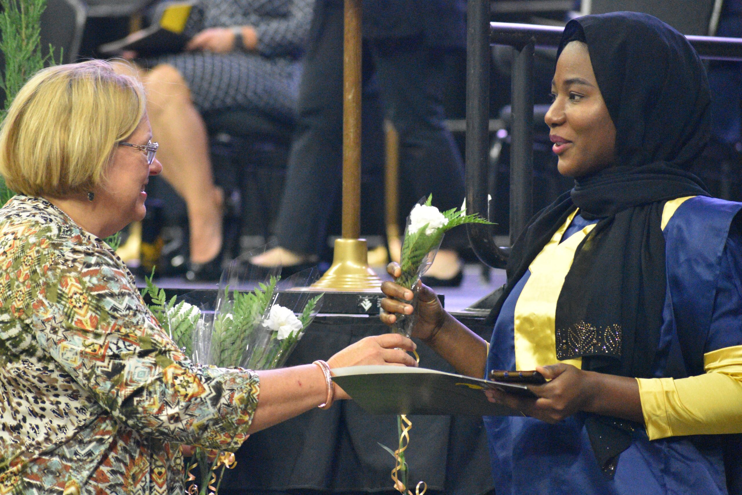 A person receiving a diploma from a person