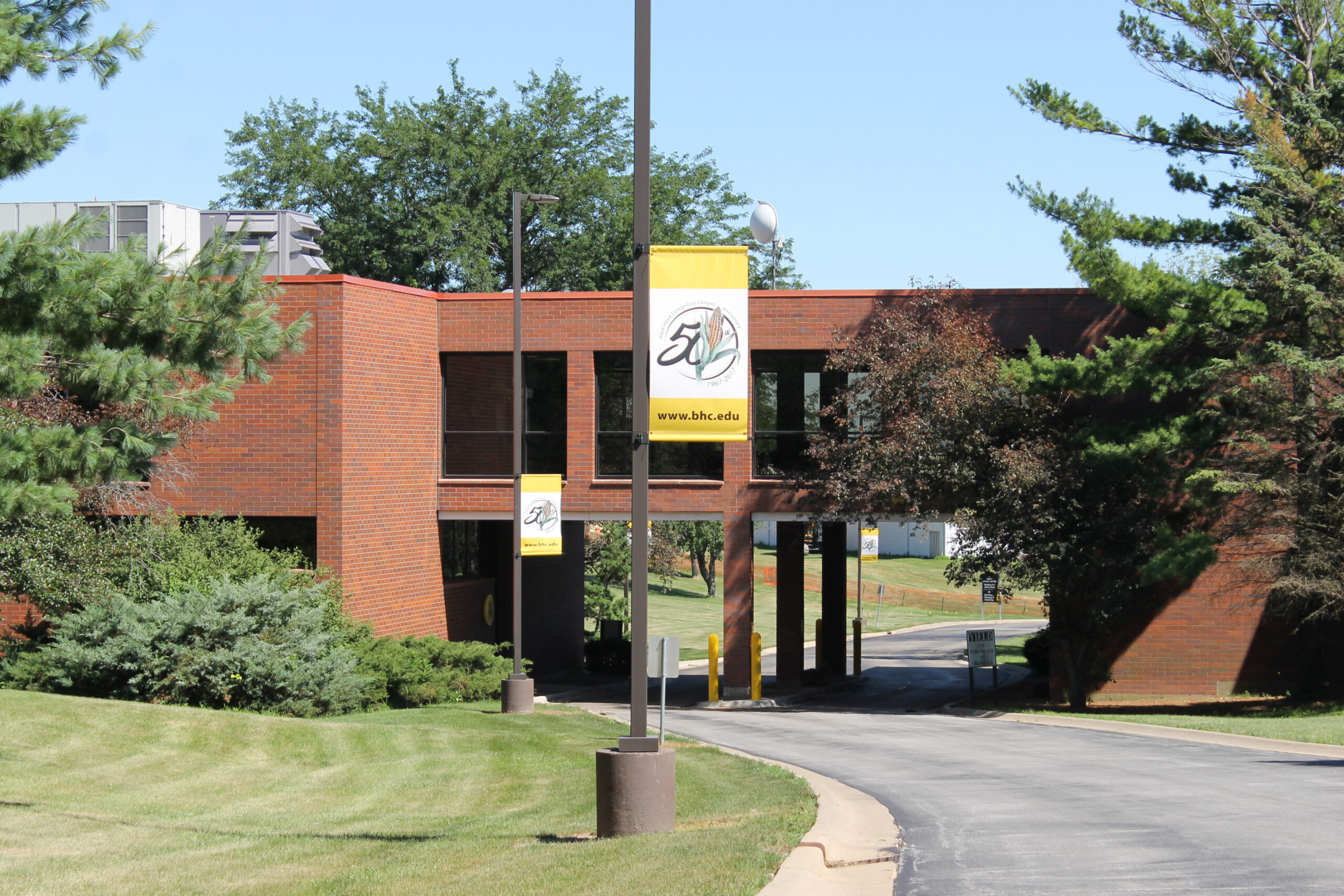 a street light with a sign on it in front of a college building