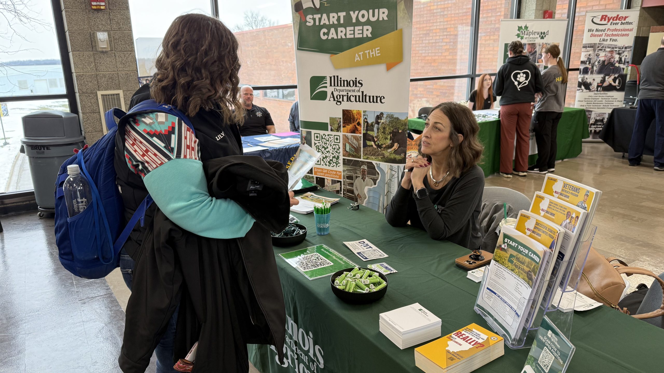 student standing at table talking to rep from Illinois Department of Agriculture.