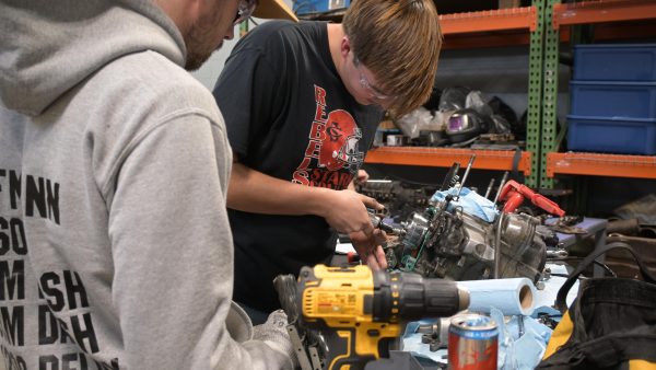 Two students working on an engine.
