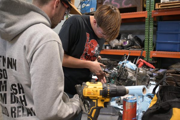 Two students working on an engine.