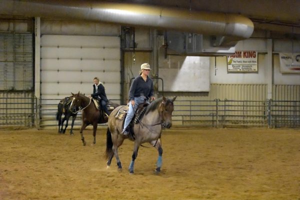 Riders practicing in indoor arena.