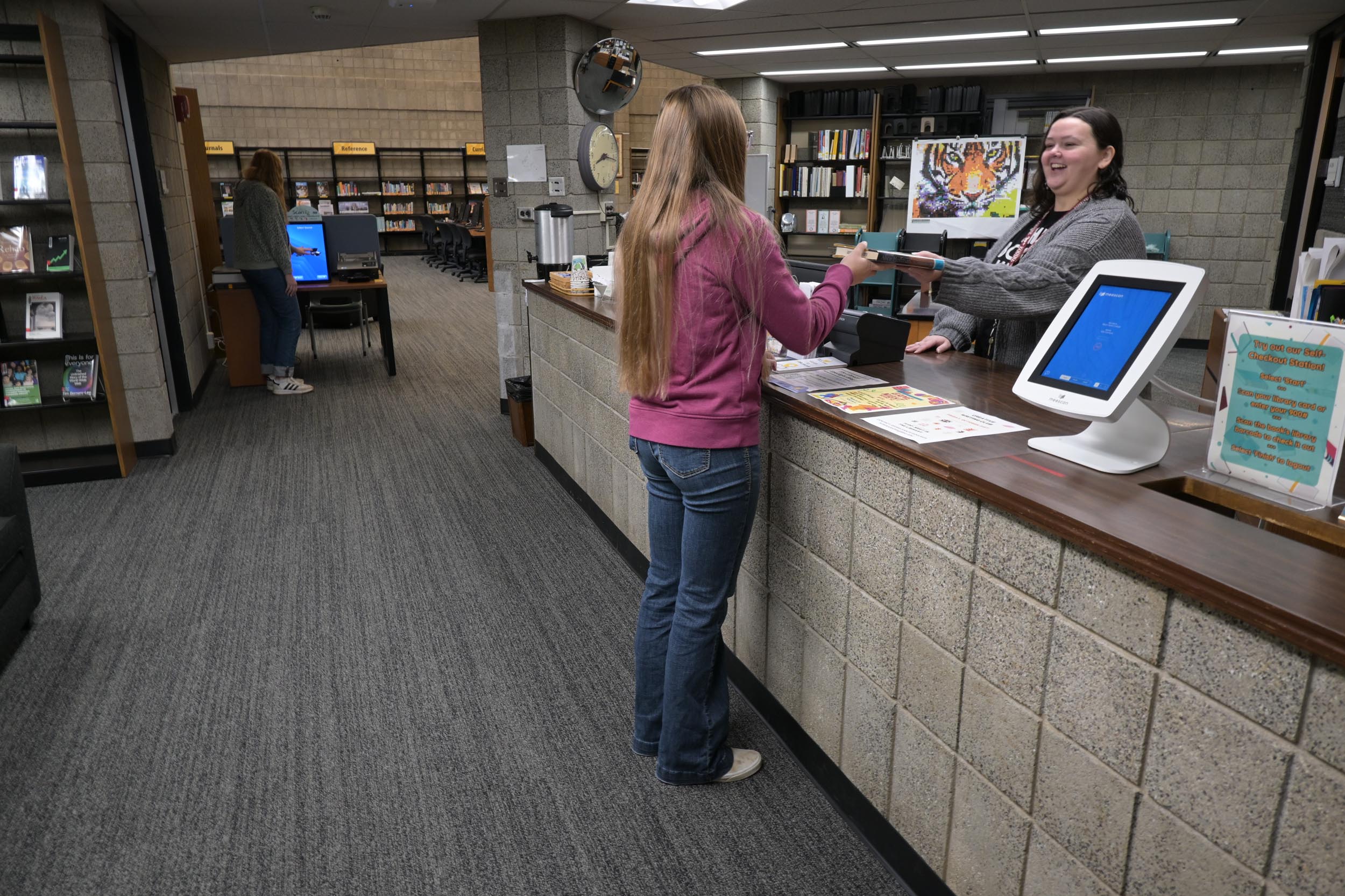Library checkout desk with patrons