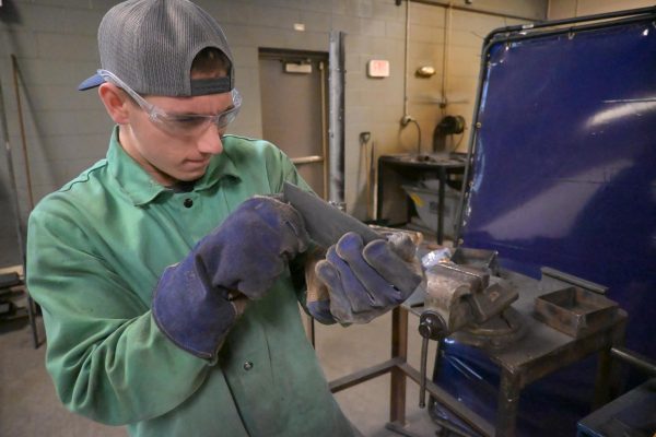 Person welding in workshop environment.