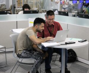 A person sitting at a table with a laptop