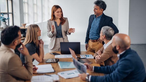 A vibrant office scene shows a team engaging in a dynamic discussion, showcasing a collaborative environment that fosters creativity and teamwork among the members.