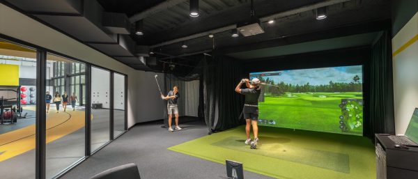 Softball roster A group of people playing golf on a simulator.
