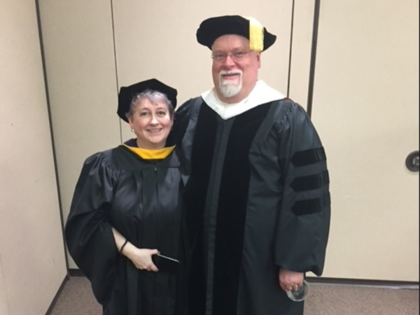 A man and woman in graduation gowns