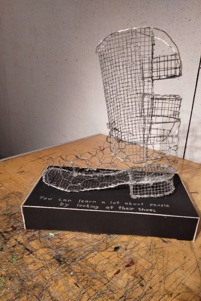 A sculpture by makayla craig which is a cowboy boot constructed from chicken wire