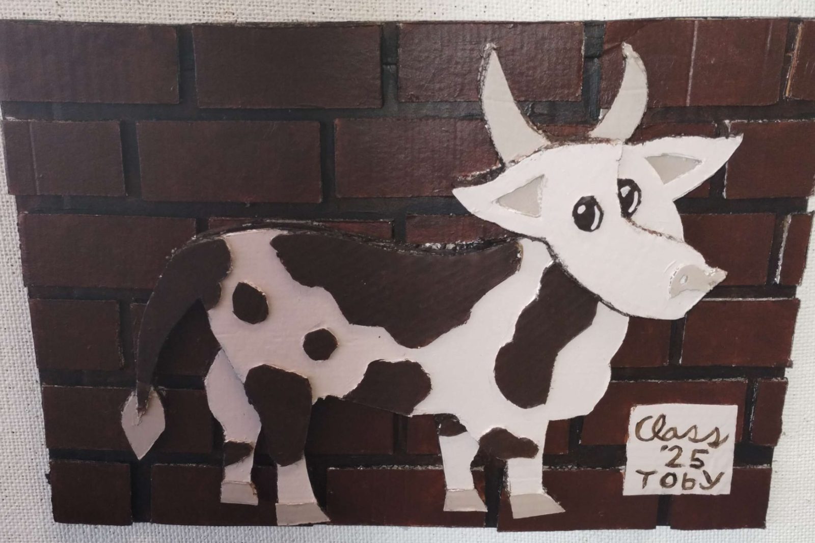Cow artwork on a brick wall.