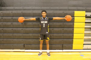 A man holding two basketballs; men's basketball
