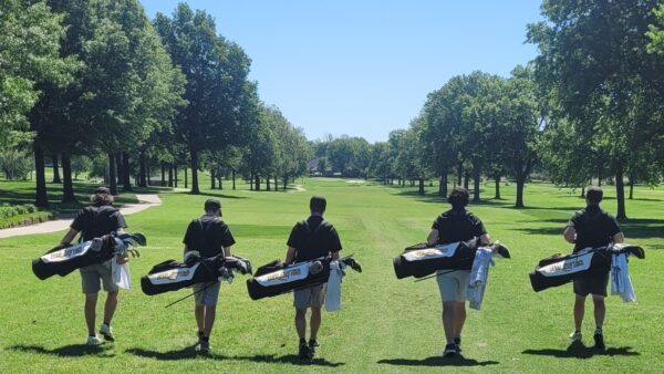 A group of people carrying golf clubs