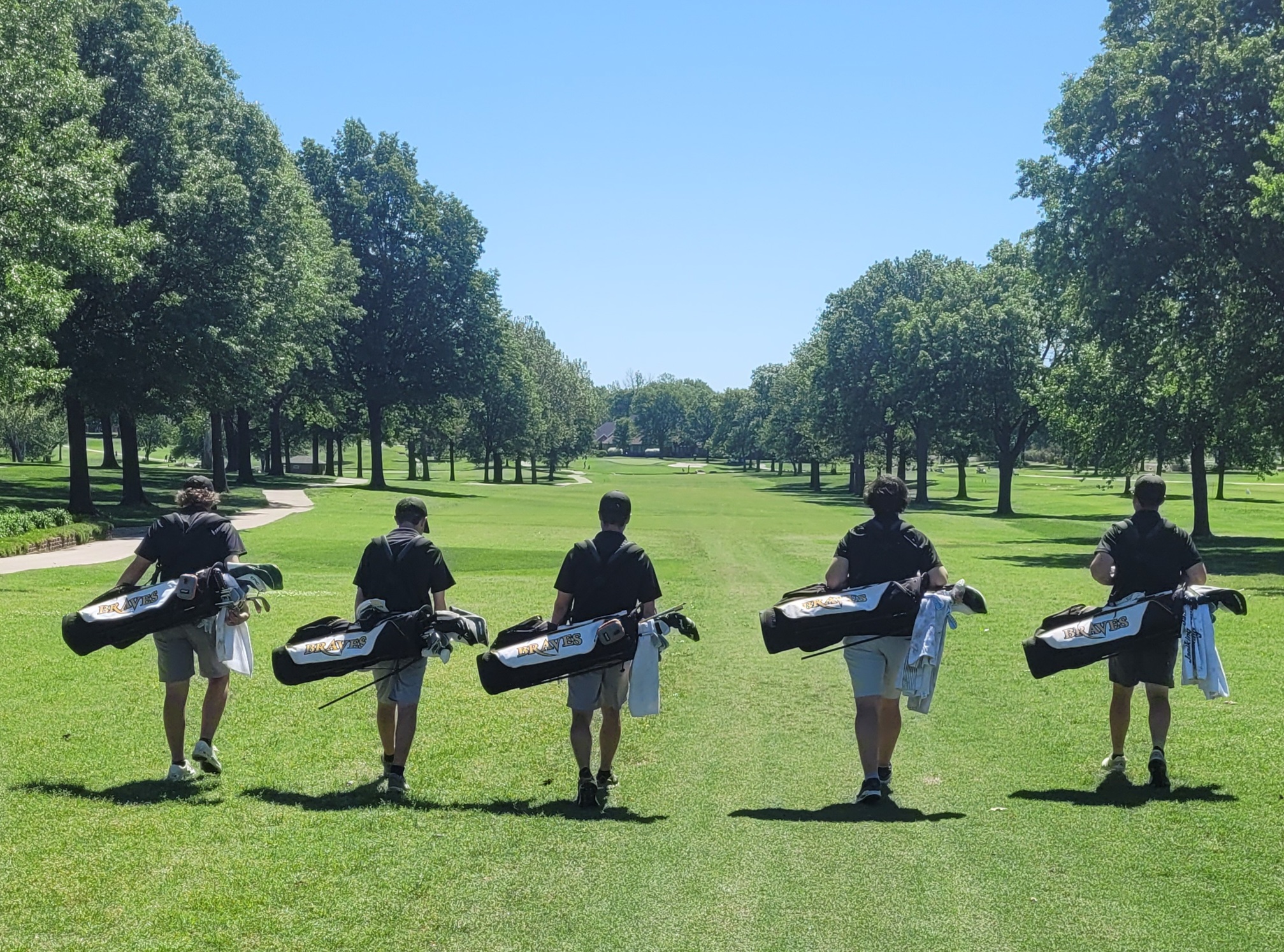 A group of people carrying golf clubs