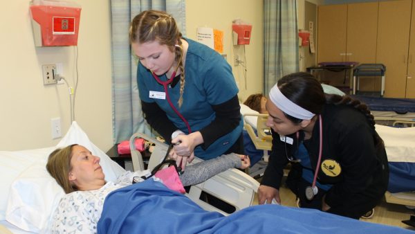 Nursing students attending to patient