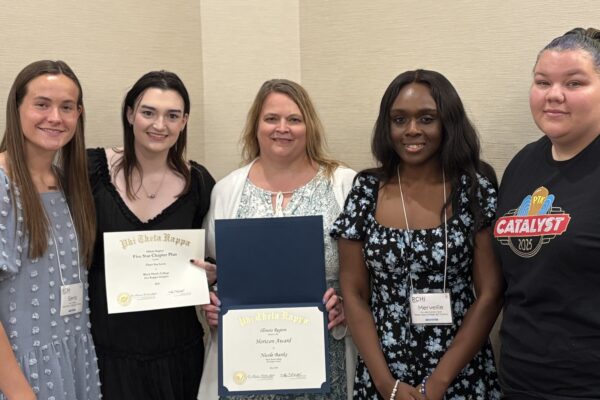 5 people standing and smiling at camera.
